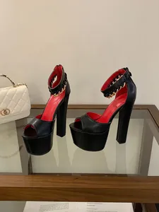 Side view of black platform high heel sandals with gold chain and red insole detail