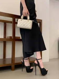Dettaglio di eleganti tacchi a spillo platform in pizzo nero ricamato da donna