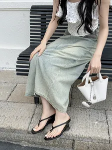 French minimalist black thong wedge sandals shown worn on model with denim skirt