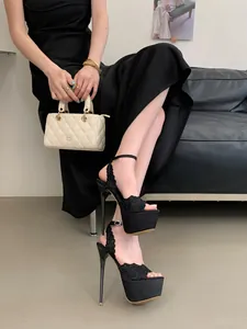 Dettaglio di eleganti sandali neri con plateau in pizzo e tacchi a spillo altissimi