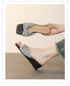 Dettaglio dei sandali con zeppa intrecciati argento da donna, design slip-on alla moda.
