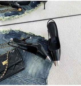 Elegant black patent leather slingback high heels with pointed silver metal toe caps.
