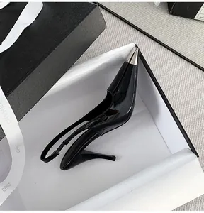 Close-up detail of black patent leather slingback pumps with silver metallic pointed toe