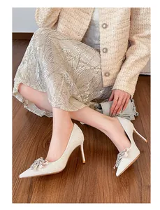 Elegant French style sequin high heels featuring a sparkling crystal bow on model