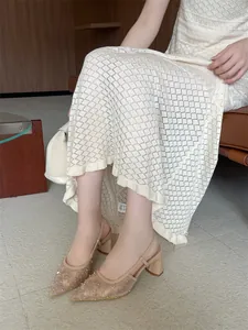 Detalle de zapatos destalonados de encaje beige con punta y elegantes tacones anchos