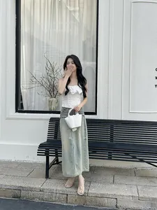 White slim strap thong sandals on model in a stylish street setting