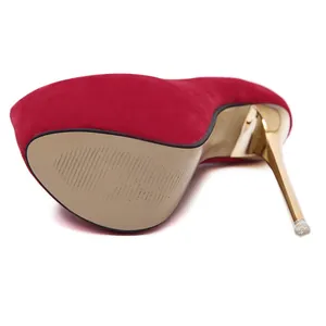 Macro view of red suede platform pumps showing the golden stiletto heel and sole details.