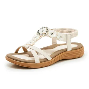 Detailed side view of Bohemian sandals with white floral decorations and elastic straps