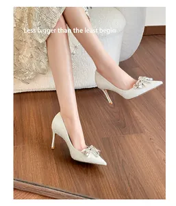 Detail view of silver sequined wedding shoes with crystal bow and high heels