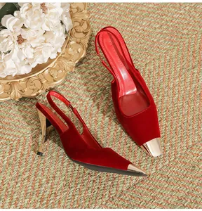 Close-up detail of red velvet slingback high heels with gold metallic pointed toe caps