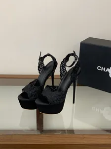 Primo piano del ricamo in pizzo nero e plateau sui sandali con tacco da donna