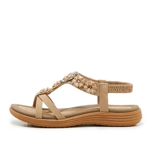 Side view of bohemian beige sandals with floral bead embellishments and elastic strap.