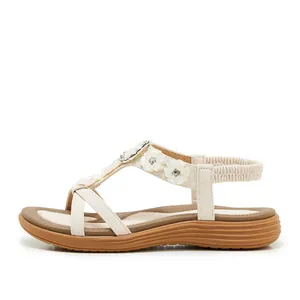Side view of cream bohemian sandals with decorative flowers and elastic strap