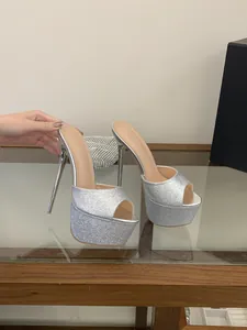 Detailansicht sexy silberner Glitzer-Plateausandalen mit Pfennigabsatz.