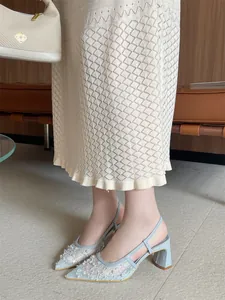 Detalle de sandalias de encaje azul claro con perlas, punta fina y tacón de bloque