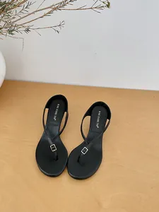 Top view of minimalist black thong sandals featuring a silver buckle and wedge heel