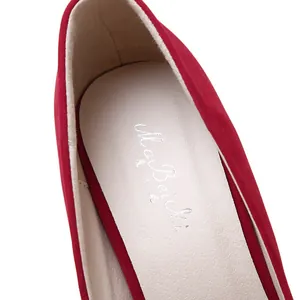 Macro view of the soft insole and brand logo inside the red suede high heel shoe