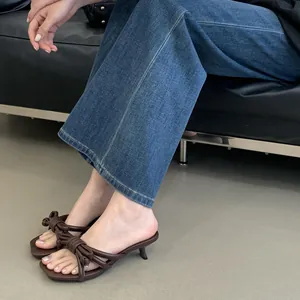 Λεπτομερής προβολή καφέ πέδιλα με χαμηλό τακούνι, δεμένους φιόγκους και τετράγωνη μύτη