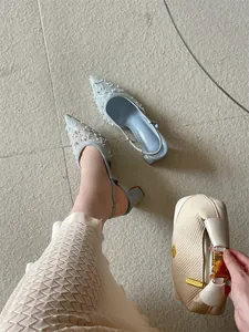 Primer plano detallado de tacones de encaje azul claro con perlas elegantes