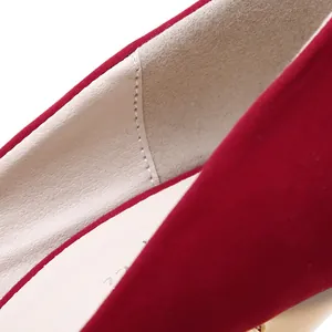 Macro close-up detail of red suede high heel shoe showing soft texture and fine stitching