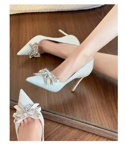 Detail of French style silver sequin wedding pumps featuring elegant rhinestone bow decoration