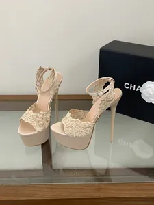 Dettaglio del ricamo in pizzo elegante su sandali nude con tacco a spillo e plateau