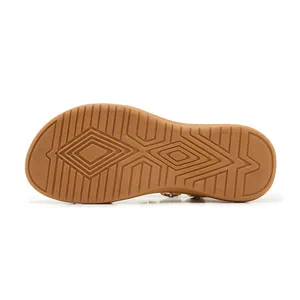 Close-up detail of the anti-slip geometric pattern on the tan sandal rubber sole