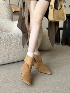 Elegant tan suede pointed-toe ankle boots with low chunky heel and crisscross design