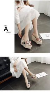 Floral wedge slide sandals with handmade bead accents shown on model feet in an indoor setting.
