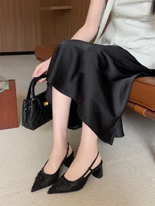 Elegantes salones de encaje negro con punta fina y tacón grueso en un entorno de estilo de vida