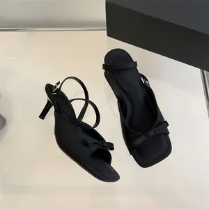 Elegant black French style high heels with bow detail and slim ankle strap.