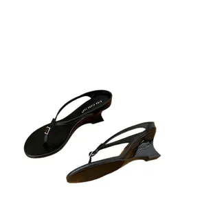 Eleganti sandali infradito neri con zeppa, cinturini minimalisti e un raffinato tacco alto.