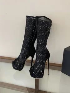 Detailed view of black mesh stiletto boots featuring sparkling rhinestone embellishments and platform