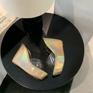 Μοντέρνα ιριδίζοντα πέδιλα με διαφανή λουράκια σε κομψό μαύρο τραπέζι