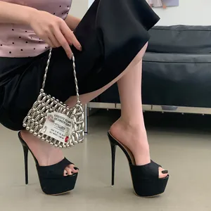 Detailed side view of high-heel platform slippers with shiny black finish and open toe