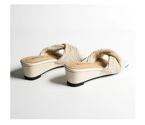 Vista dettagliata di sabot bassi intrecciati da donna con eleganti cinturini in paglia