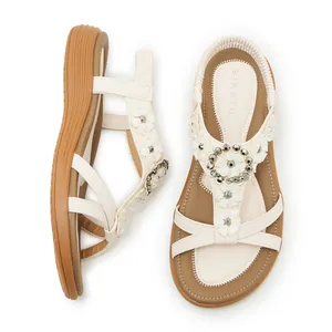 Bohemian style white flat sandals with floral buckle embellishments and elastic back strap