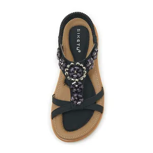 Close-up detail of stylish bohemian black sandals with purple floral bead embellishments