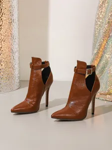 Nahaufnahme brauner spitz zulaufender High-Heel-Stiefel mit dekorativen Ausschnitten