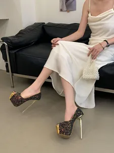 Close-up of black glitter peep-toe high heels featuring gold platform and stiletto