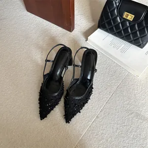 Vista de detalle de los zapatos slingback de encaje negro con perlas y lentejuelas
