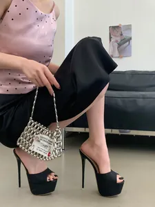 Schwarze Glitzer-Plateau-Stilettos, getragen von einem Model in modernem Ambiente
