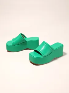 Side view of bright green platform wedge sandals with thick soles and soft padded strap