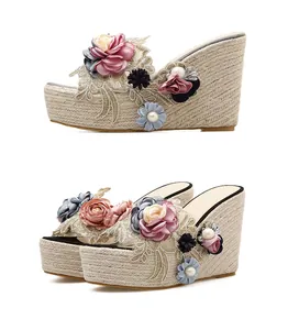 Detail of handmade floral wedge sandals with platform espadrille sole and pearl accents