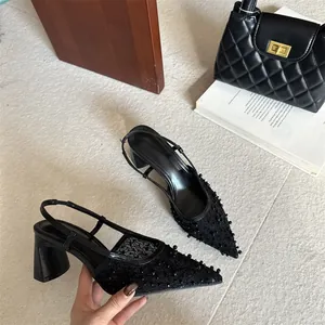 Primer plano de zapatos slingback de encaje negro con punta fina y tacón grueso francés.