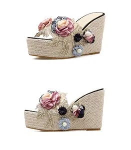 Detailed side view of floral wedge sandals with straw platform and pearl accents