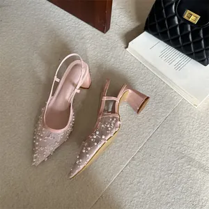 Elegantes tacones destalonados de punta rosa con delicado encaje y perlas.