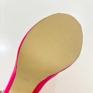 Macro detail of the anti-slip tan sole texture on a pink platform peep-toe high heel.