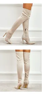 Detailed view of beige suede over-the-knee boots with high stiletto heels and side zipper.