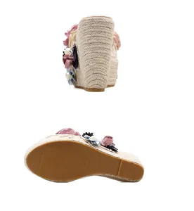 Detail view of women's floral wedge sandals with handmade beading and woven platform